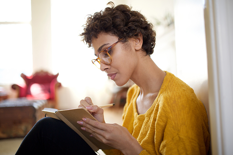 woman-sitting-and-writing-in-journal