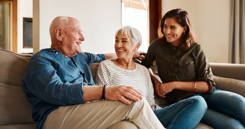 An adult woman spends time with her older parents, something that many only-child caregivers do each day.
