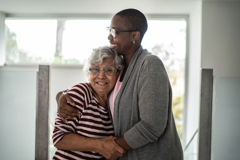 A woman embraces her mother who suffers from anxiety. She understands there is a connection between anxiety and older adults and is helping her mother find strategies to manage the condition.